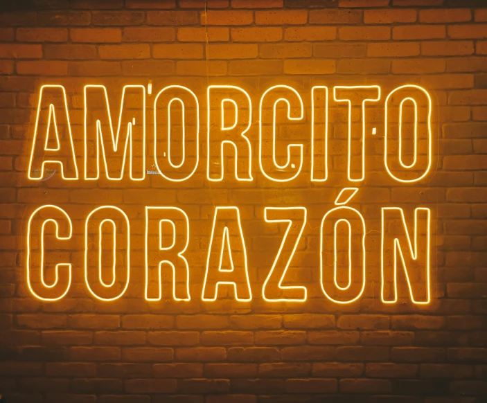 a brick wall and a neon sign reading amortottoo corazonen