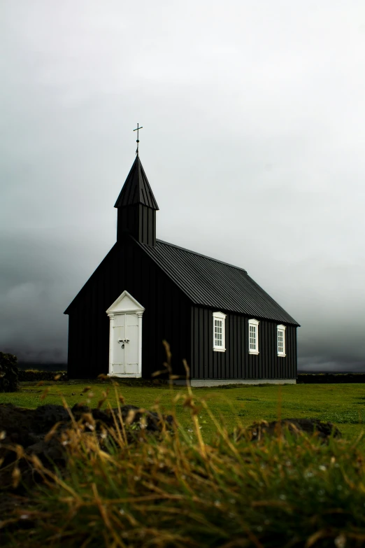 a black and white church with the sky in the background