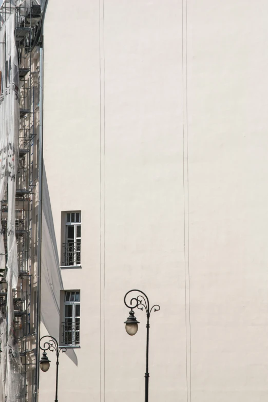 a clock on a pole near buildings with lots of windows