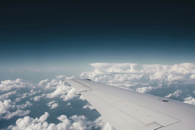 the view from an airplane flying in the sky over clouds