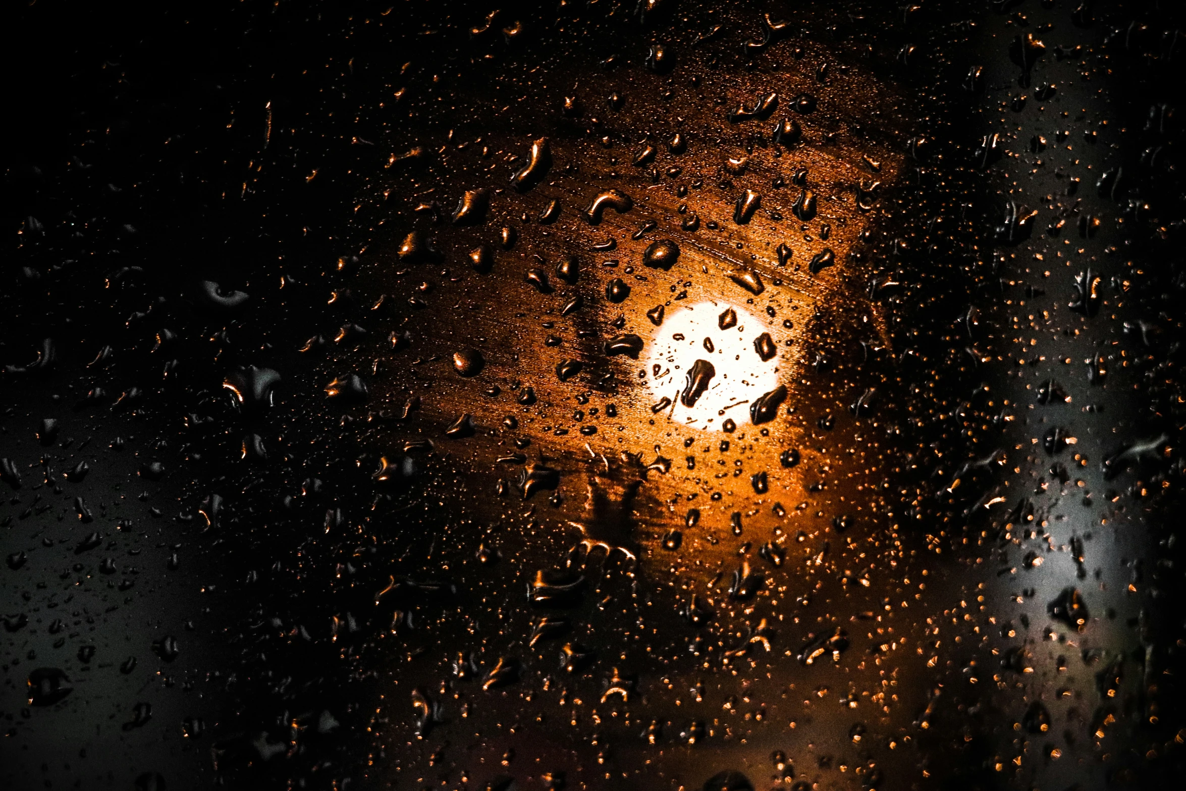 a streetlight in the rain from a car windshield