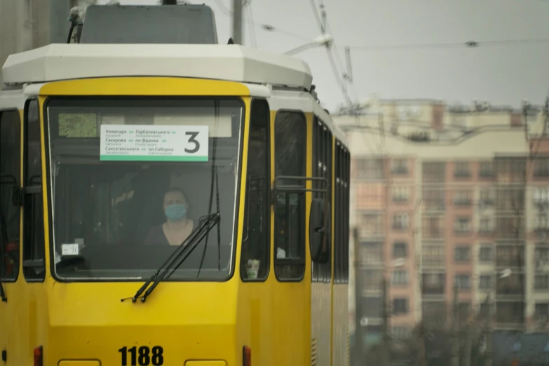 a yellow city trolley moving on the tracks