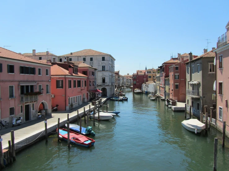 a canal that has many small boats on it