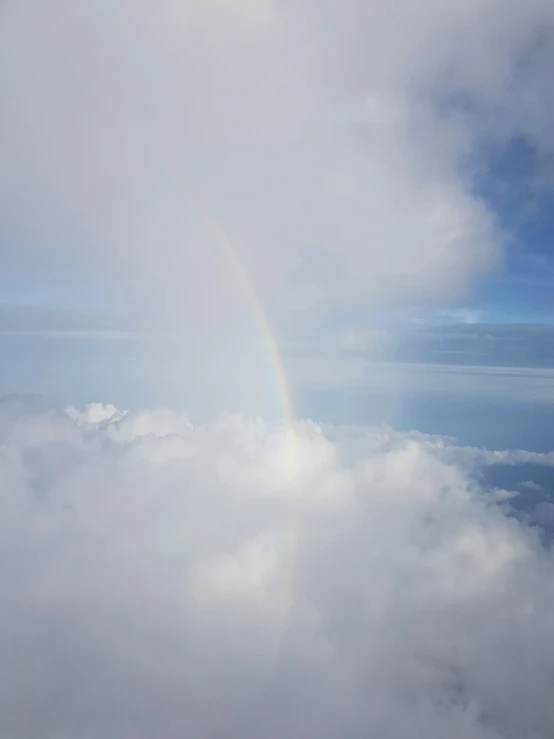 the sky is filled with clouds, and there is a rainbow in it