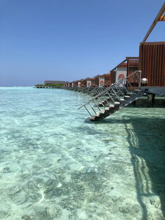 water is moving near a boardwalk on an ocean