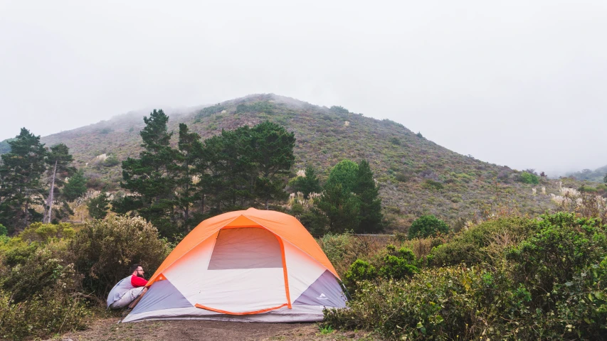 a tent is pitched up near a mountain