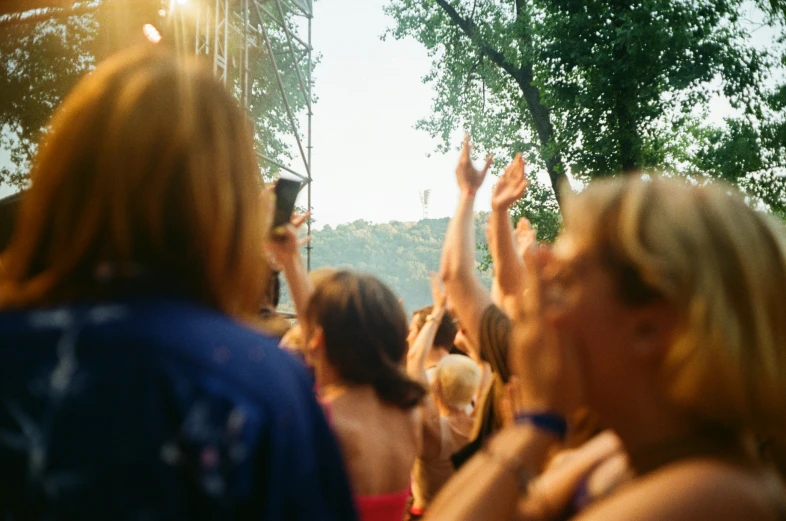 a crowd of people sitting next to each other at a music festival