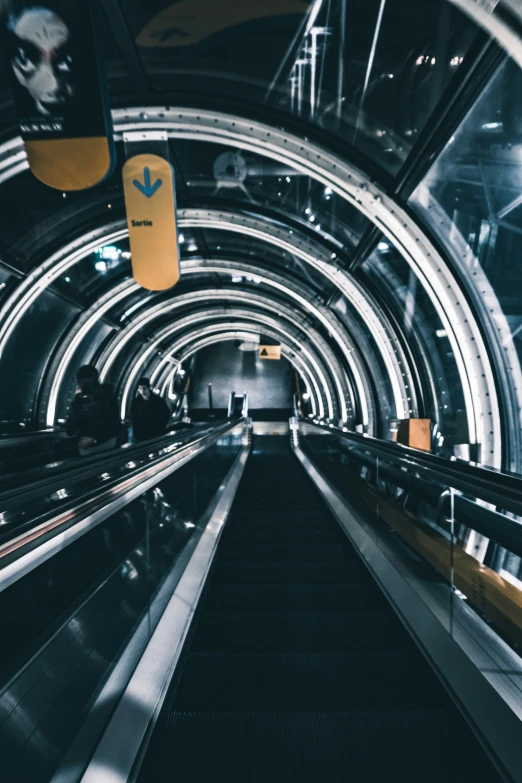 a large long silver escalator with people on it