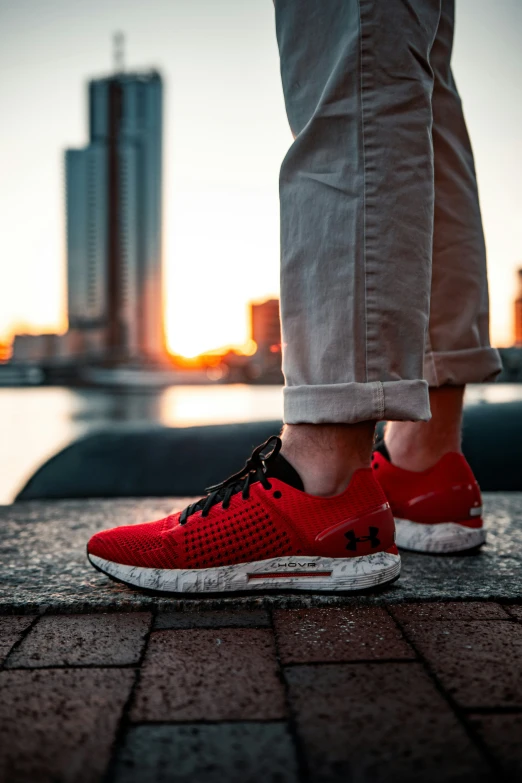 a person standing on top of a red sneakers