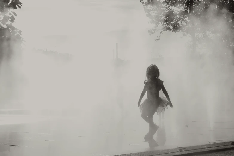 a person in black and white standing in the middle of a fountain