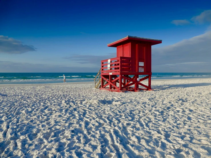 a lifeguard booth sits in the sand on the beach