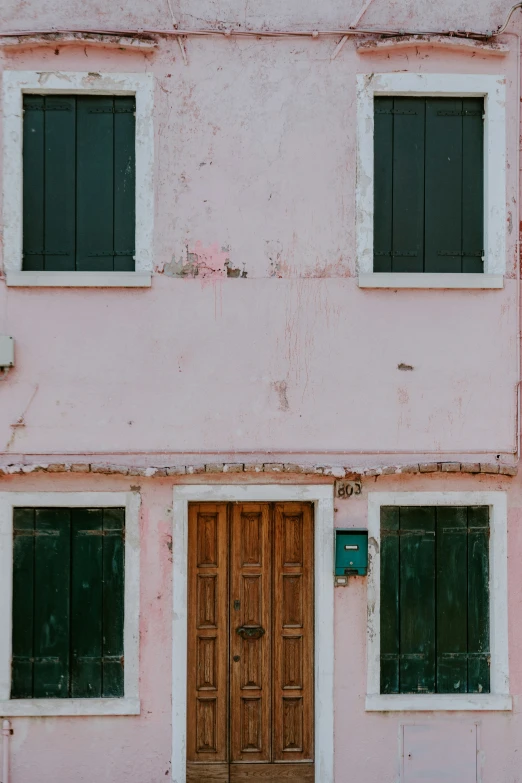 an old house with green windows and brown door