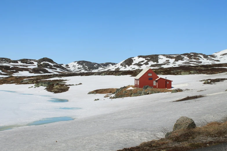 the red house is nestled on a snowy mountain