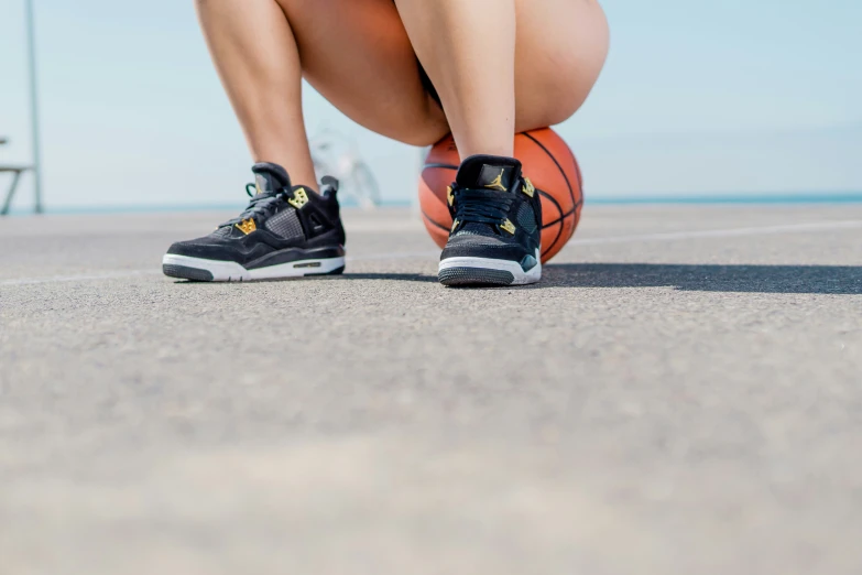 legs and shoes on the ground holding basketball