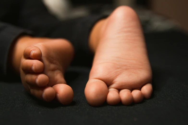 the foot of a child is sitting on a bed