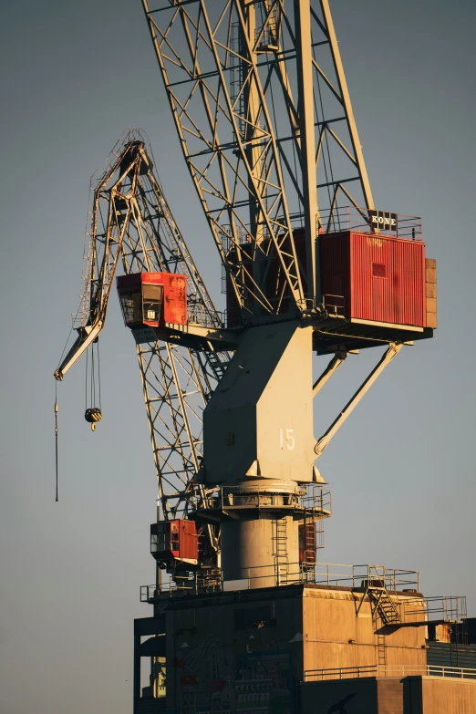 some cranes against a blue sky and one is on top