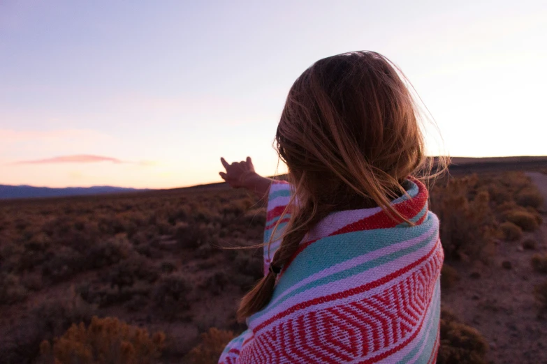 a woman in a striped blanket standing by herself