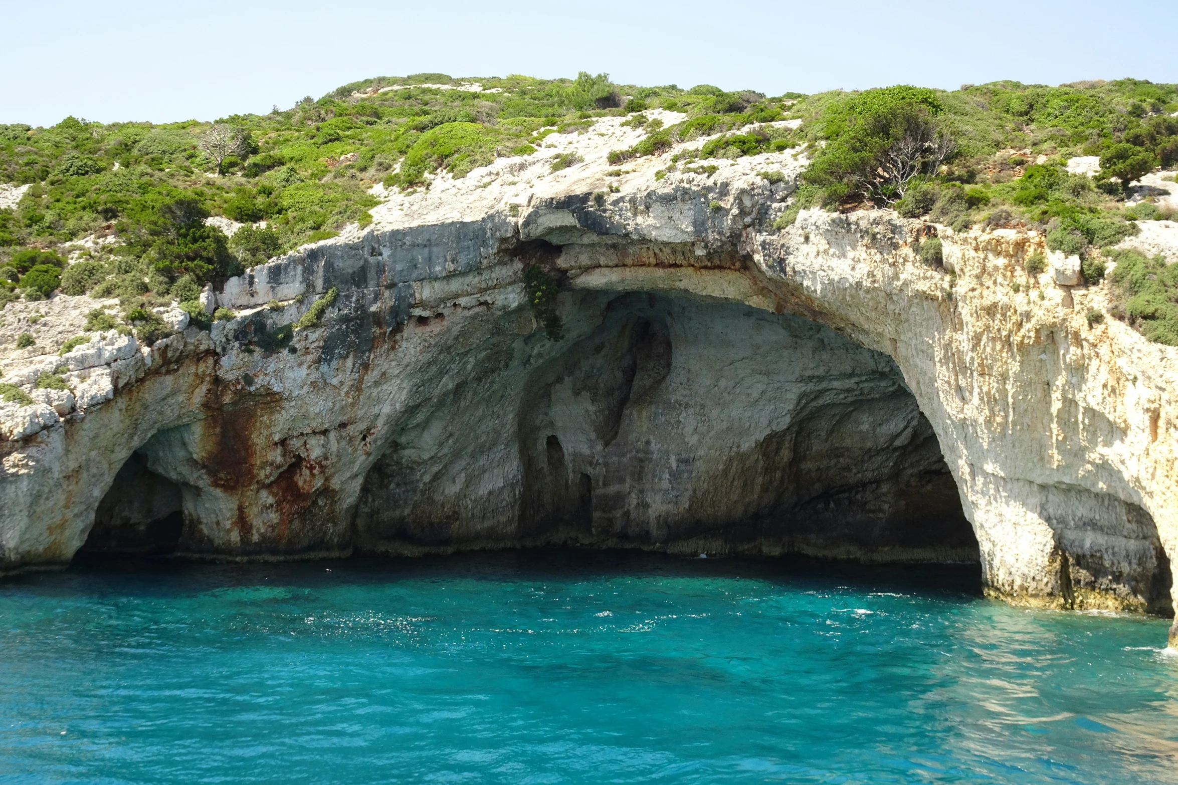 the rock formations face the water with blue hues