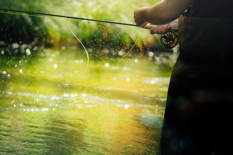 the angleer is casting the line while the man stands on the bank