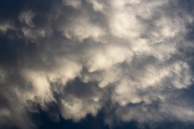 an airplane flying in the clouds under a blue sky