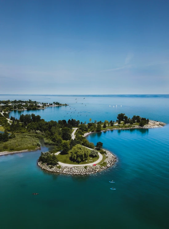 an island with a pier, and a beach in the distance