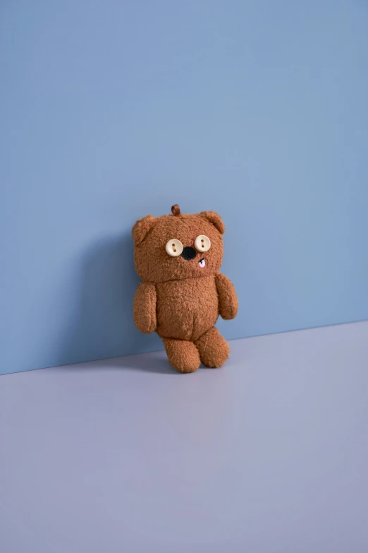 a teddy bear wearing eyeballs on a blue surface