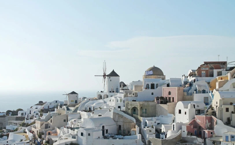 a view of a village on the side of a hill by the ocean