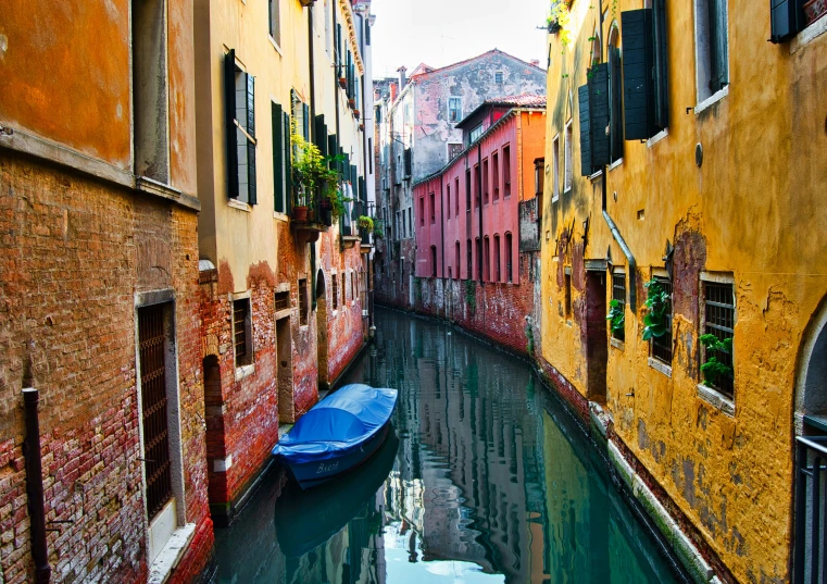 a blue boat on the water next to buildings