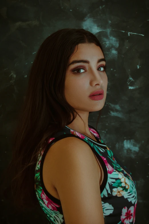 a woman with long dark hair wearing a tank top