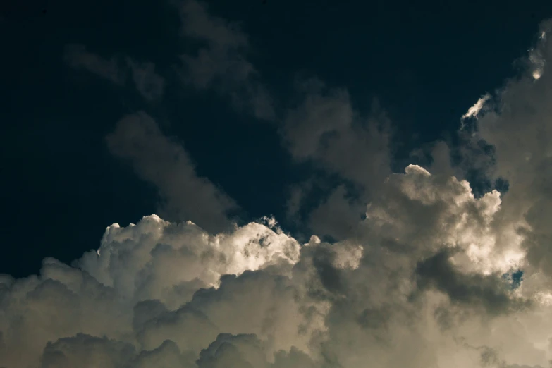 a plane is seen in the clouds, with blue skies in the background