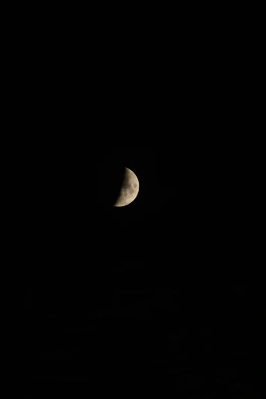 the moon is behind the dark black sky
