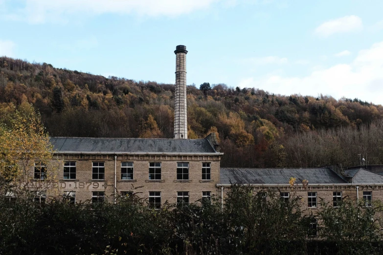 an old brick building in front of a hillside