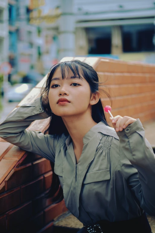 woman in green shirt leaning on a bench with tooth brush