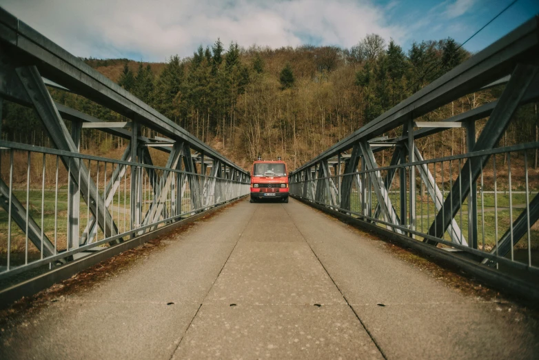 a bus driving across a bridge over a field