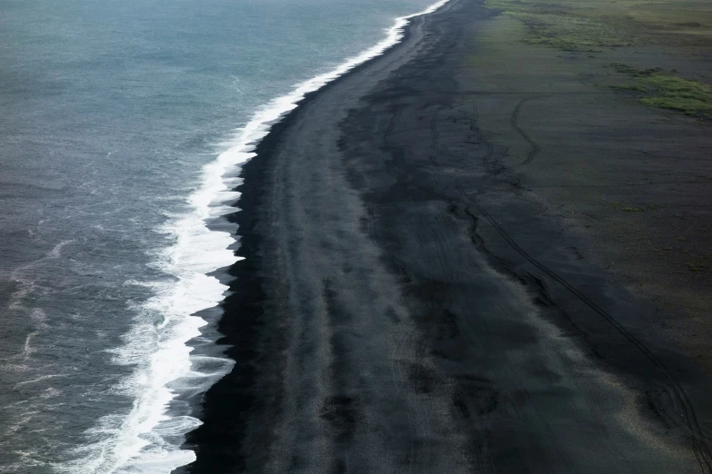 the black beach is covered with some waves