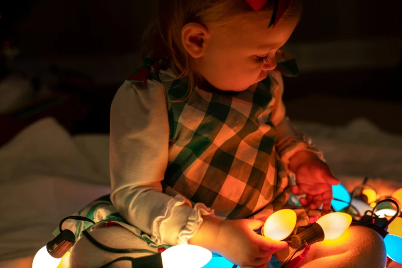 a toddler playing with lights while on a bed