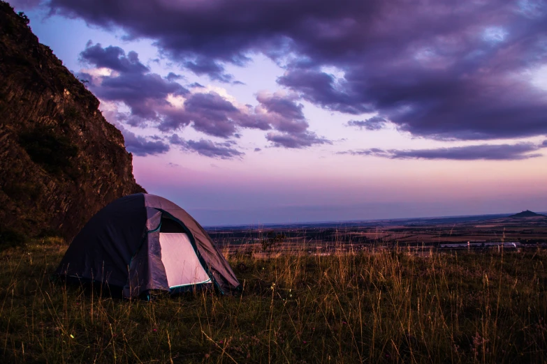 the large tent is pitched up on the side of the hill