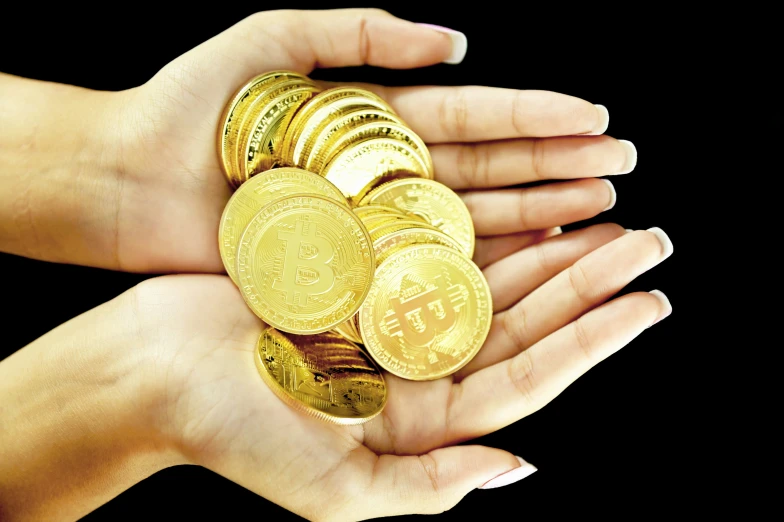 woman holding some gold coins in her hand