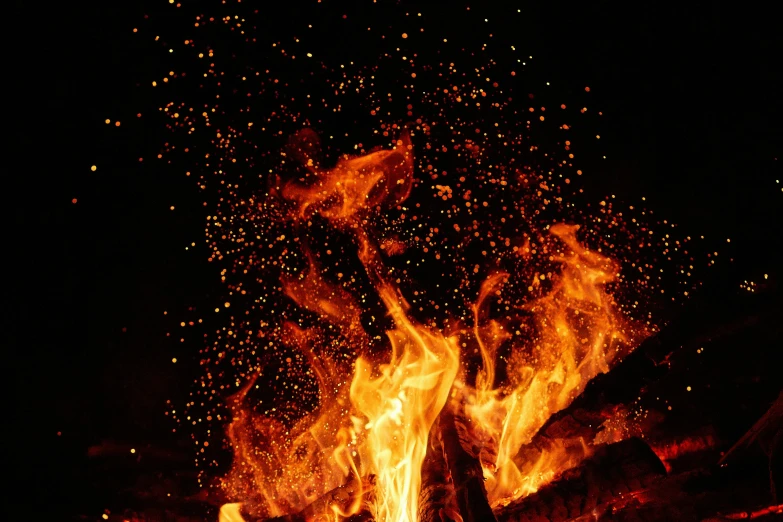 a fire lit with orange flames in the night