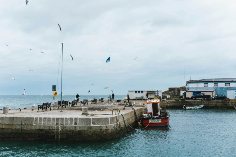 some birds are flying over a boat in the water