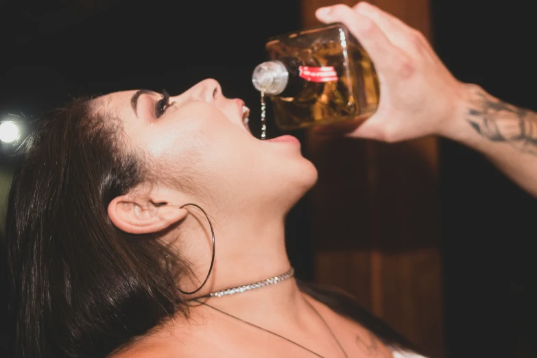 a woman in an ear ring looking at a beer in the air