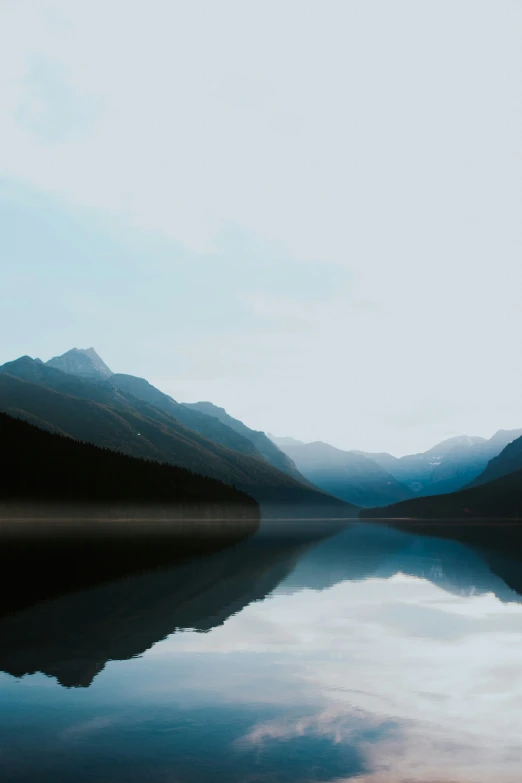 some mountains and clouds and water with a reflection in the water