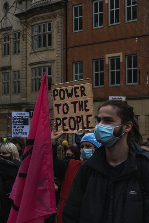 a protester holding up a sign with words power to the people on it