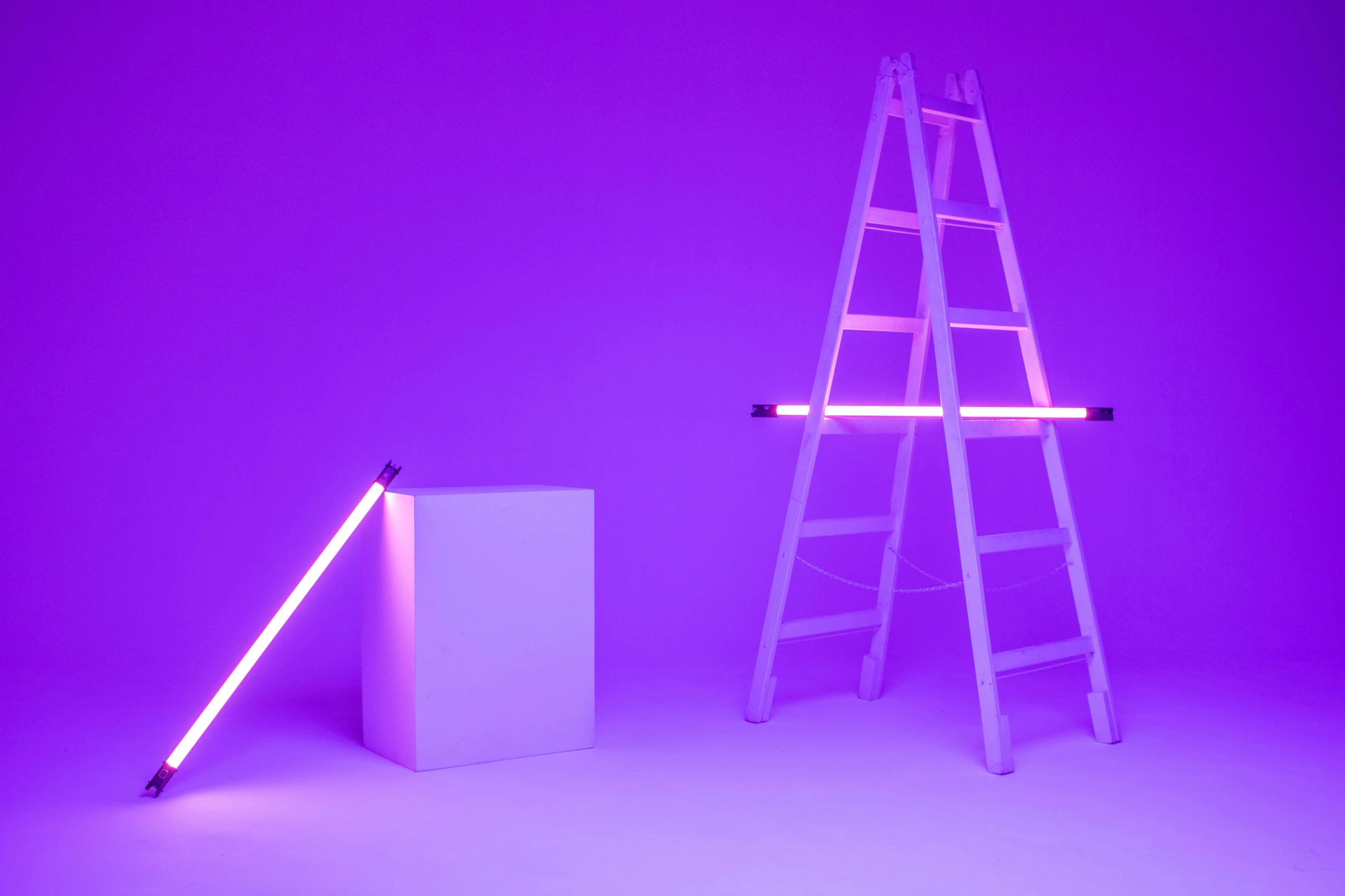 three steps on a purple background a ladder stands up beside a white box