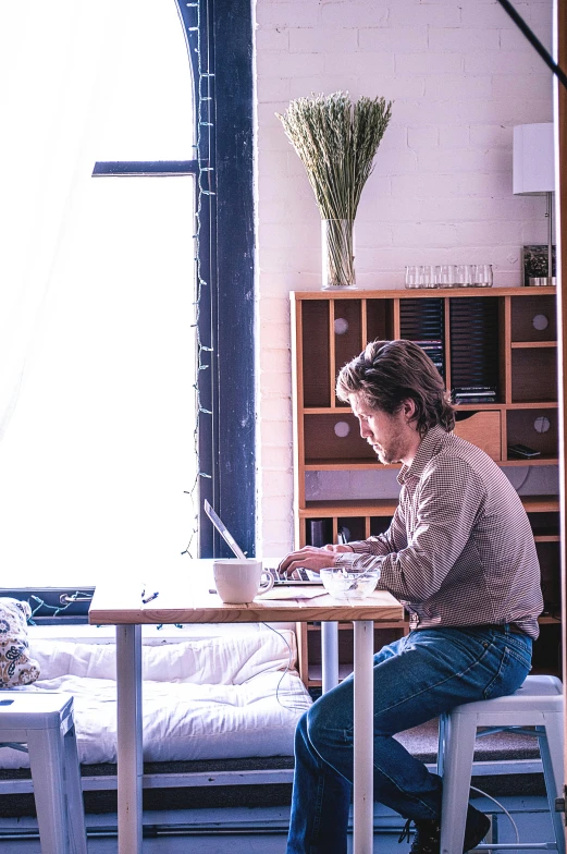 a man that is sitting at a table with a laptop