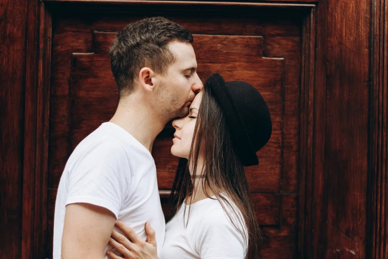 a man kissing his wife in front of a door