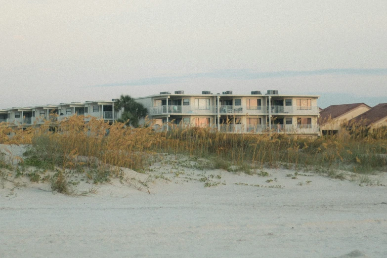 many houses sitting on the beach with sand around them