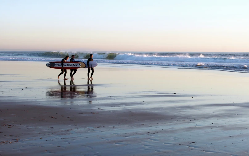 two people holding surf boards on the beach