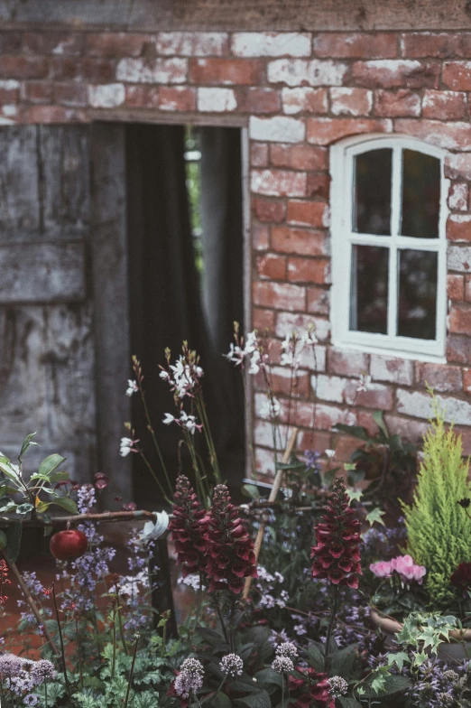 a flower garden outside of a brick house