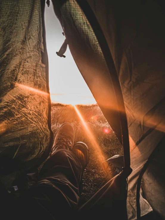 the sun is shining on top of the person in a tent